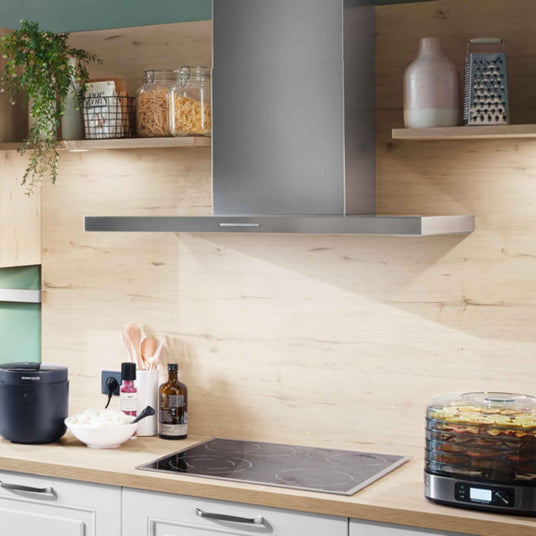 Berbel Smartline BWH ST Wandhaube aus Edelstahl über einem Kochfeld in moderner Küche mit heller Holzrückwand und offenen Regalen.