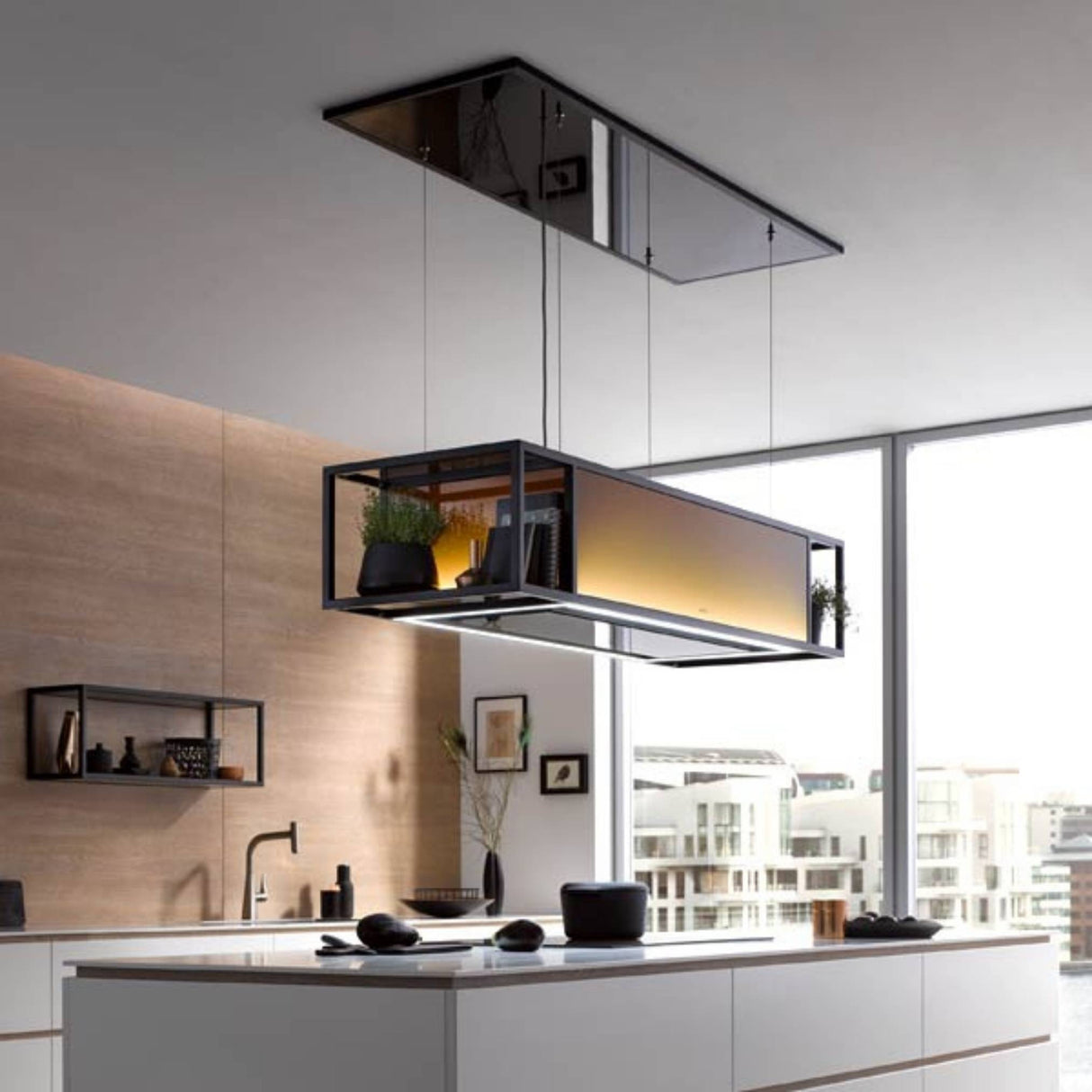 berbel Skyline Frame Inselhaube mit mattschwarzem Designrahmen und warm beleuchtetem Glaskorpus über einer Kücheninsel