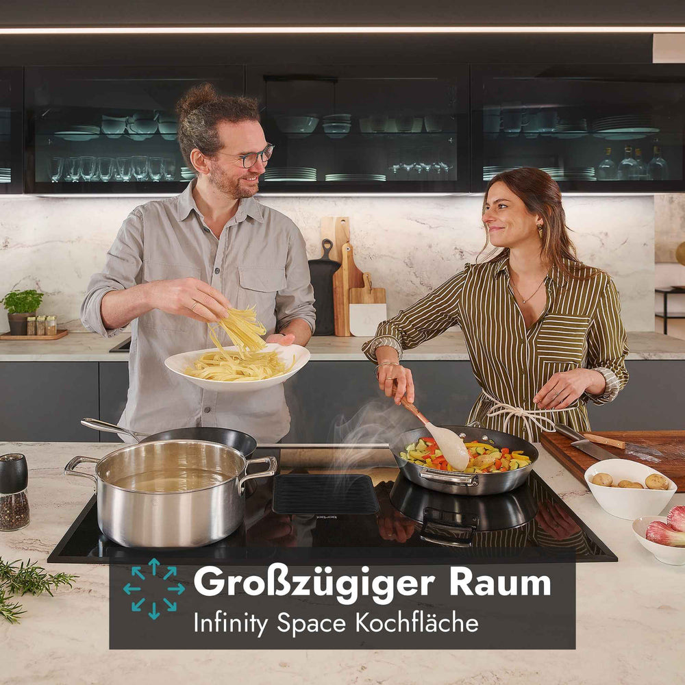 Berbel Downline Kochfeld mit integriertem Abzug und großzügiger Infinity Space Kochfläche beim gemeinsamen Kochen mit mehreren Töpfen und Pfannen.