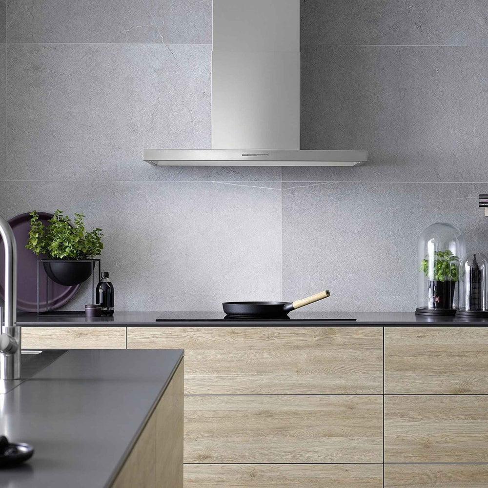 Berbel Smartline BWH ST Wandhaube aus Edelstahl über dem Kochfeld in moderner Küche mit grauer Wand und Holzfronten.