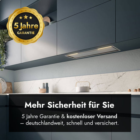 Ansicht des Falmec Lüfterbausteins Plus Green Tech, bündig integriert in dunkelblaue Küchen-Oberschränke über einer hellen Marmorarbeitsplatte. Oben links ist ein goldenes Siegel mit der Aufschrift "5 Jahre Garantie" platziert. Im unteren Bereich zeigt ein schwarzes Grafik-Overlay den Text "Mehr Sicherheit für Sie" sowie den Untertitel "5 Jahre Garantie & kostenloser Versand – deutschlandweit, schnell und versichert".