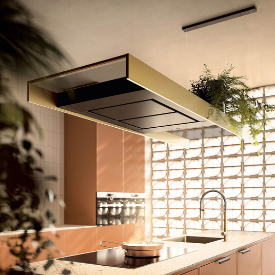 Eine hängende Falmec Light Dunstabzugshaube in warmer Bronzefarbe mit integrierter LED-Beleuchtung in einem stilvollen, wohnlichen Kücheninterieur.