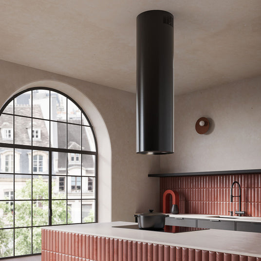 Falmec Polar Evo Inselhaube in Schwarz über einer Kochinsel in moderner Küche mit markantem Rundbogenfenster.