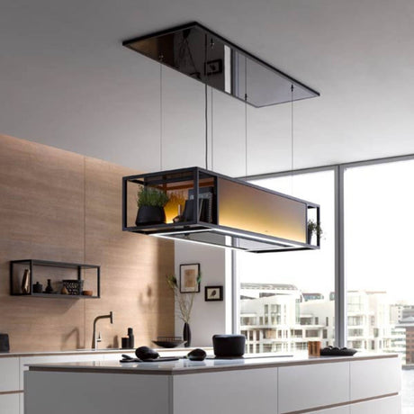 berbel Skyline Frame Inselhaube mit mattschwarzem Designrahmen und warm beleuchtetem Glaskorpus über einer Kücheninsel